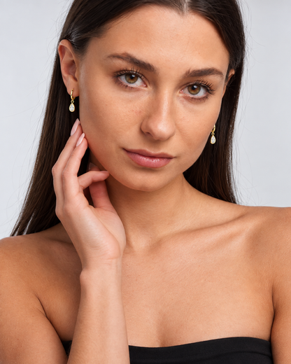 Dainty Teardrop Crystal Hoop Earrings in Gold, worn by a model in a front portrait - Ravyena