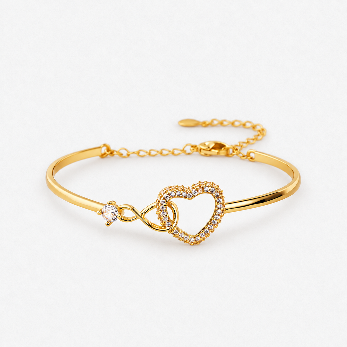 Gold coloured Infinity Heart bangle-style bracelet photographed alone on the approved off-white background