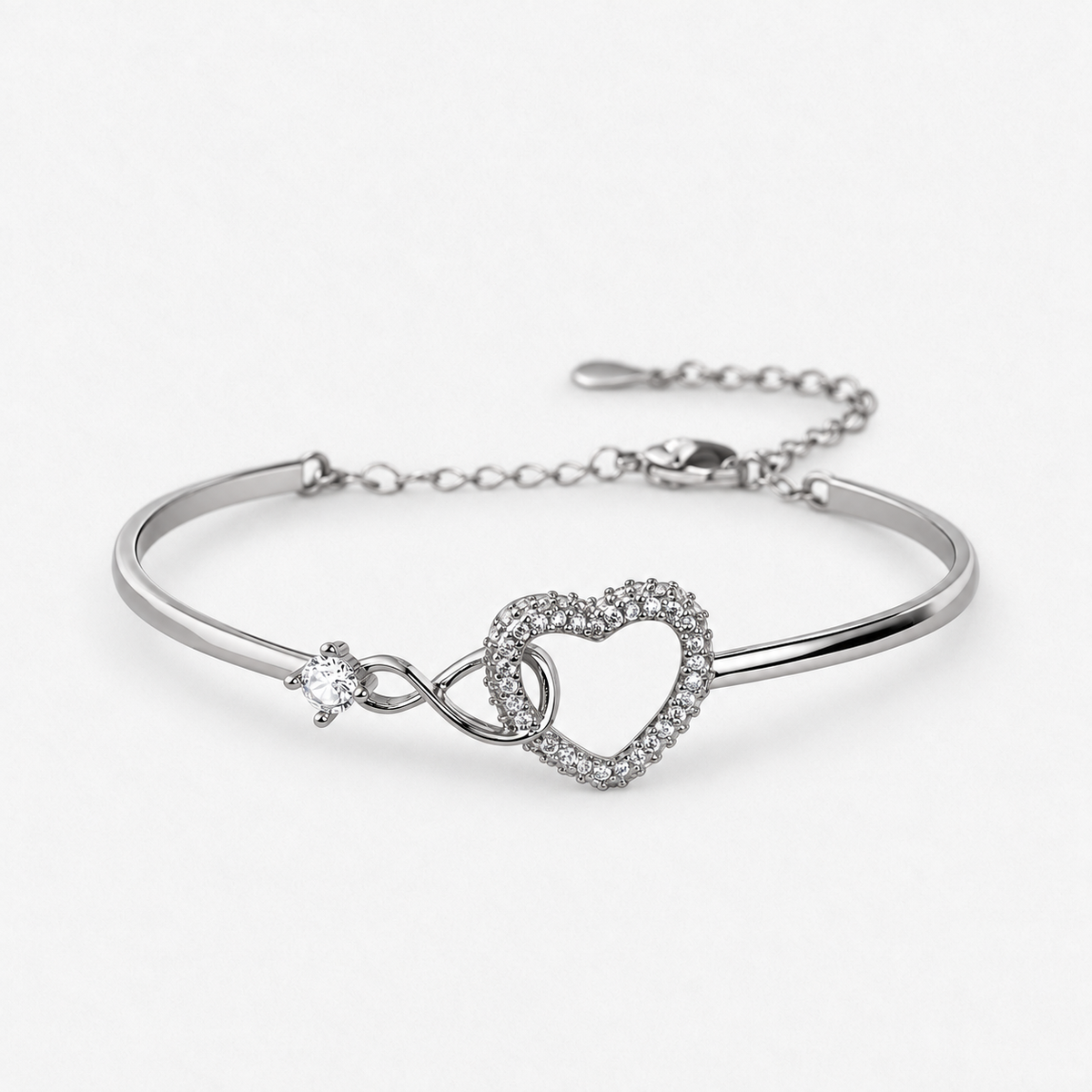 Silver coloured Infinity Heart bangle-style bracelet photographed alone on the approved off-white background