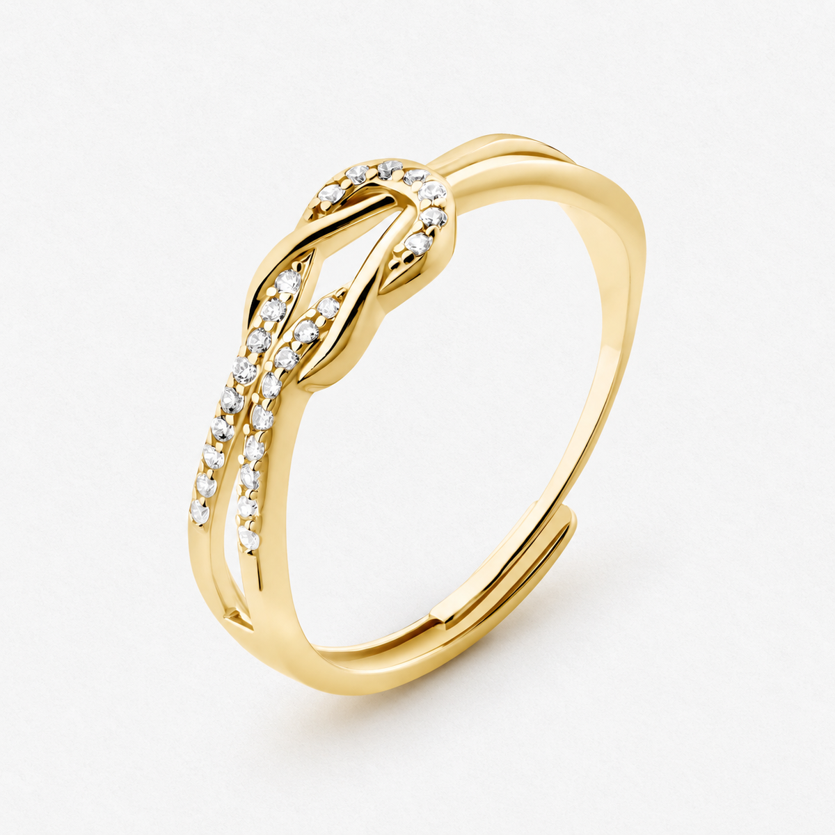 Knot adjustable ring with intertwined band and clear stone accents in a gold finish on a neutral off-white background.