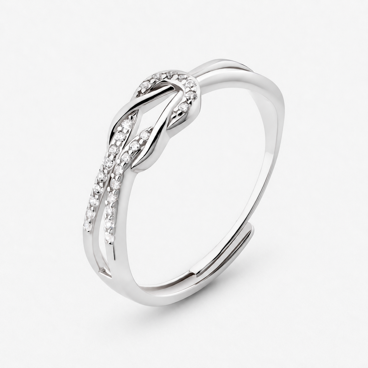 Knot adjustable ring with intertwined band and clear stone accents in a silver finish on a neutral off-white background.