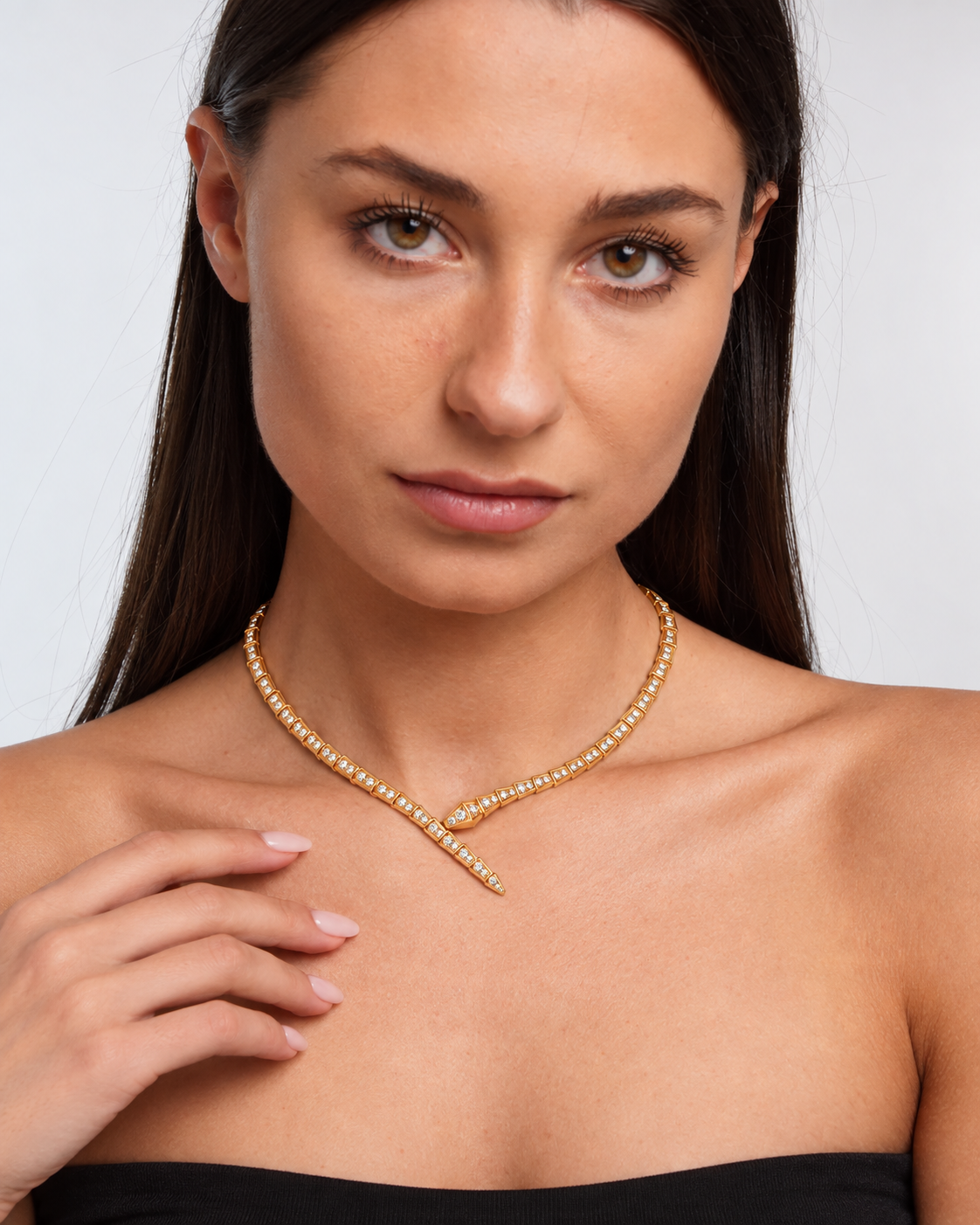 Crystal serpent choker necklace with articulated links and crossed front ends in a gold finish worn by the model.