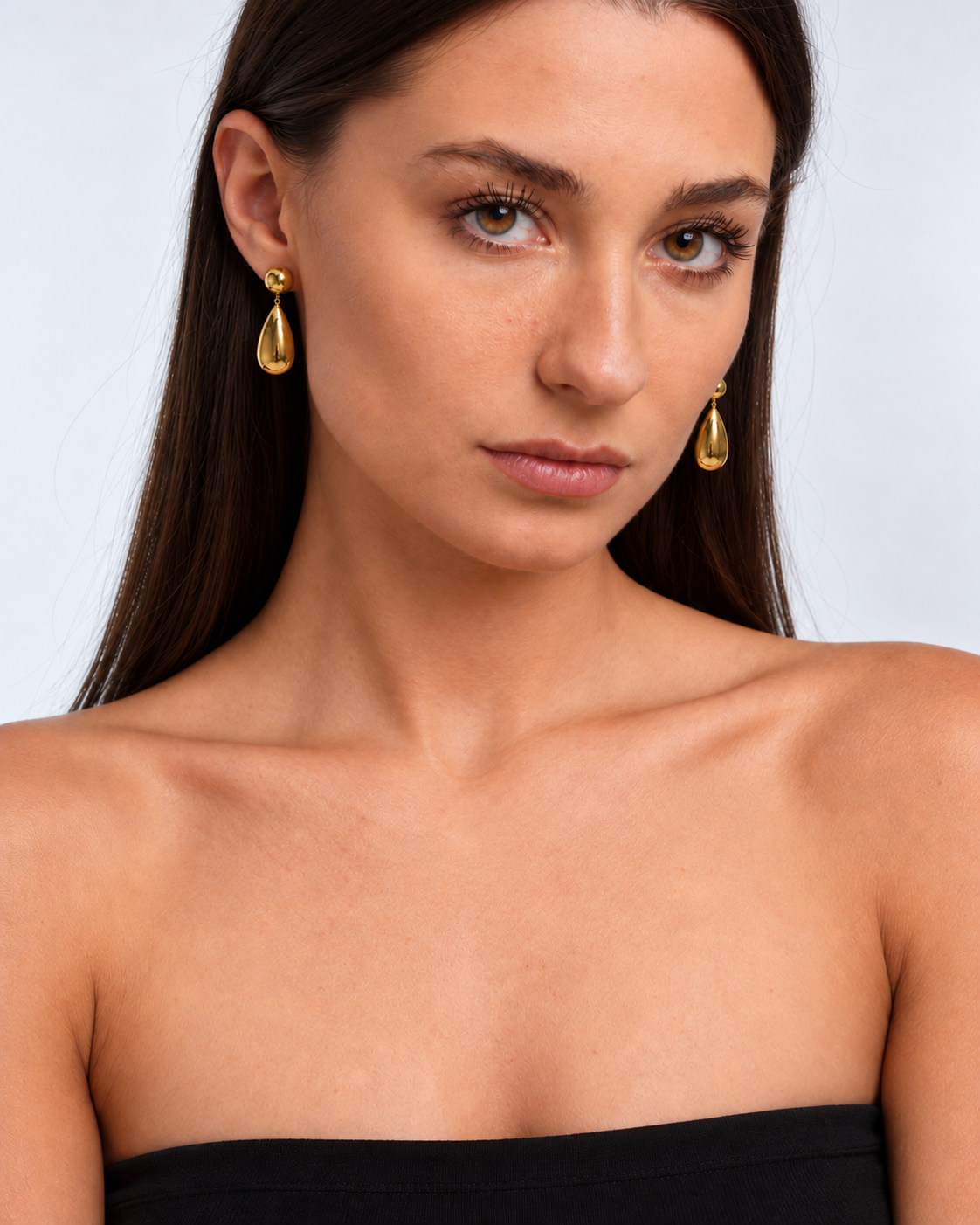 Goccia gold-coloured teardrop earrings worn in three-quarter view
