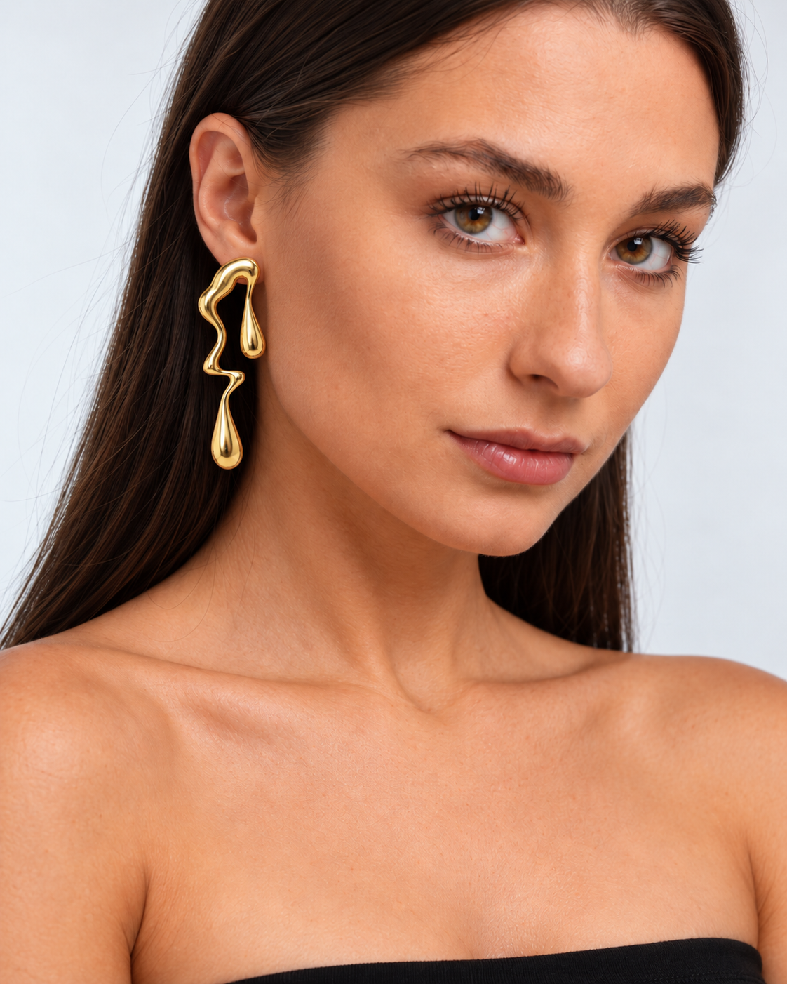 Lustrous Flow Drop Earrings in a gold finish worn by a model, portrait view