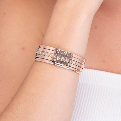 Hinged gold bangle with clover charm, side angle view