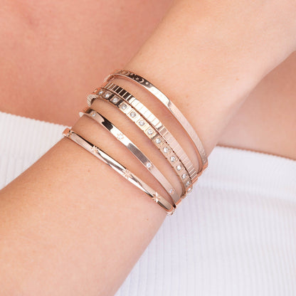 Slim clover bangle styled on a feminine wrist