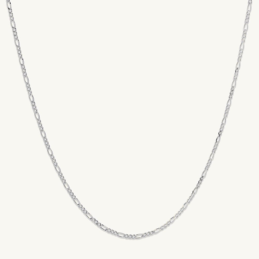 Gold figaro chain on neutral background