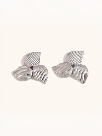Gold floral earrings on neutral background