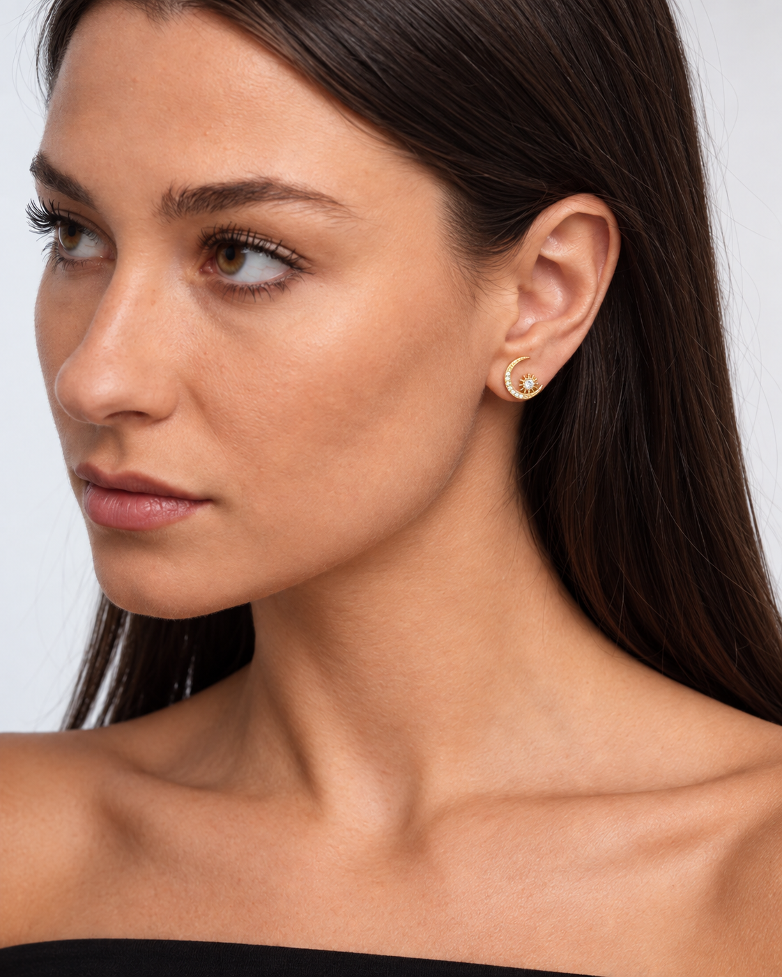 Close portrait showing the gold-coloured crescent moon stud and small starburst detail